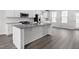 Bright kitchen island with a granite countertop and stainless steel appliances, complemented by modern gray wood floors at 1364 Chowan Ave, Durham, NC 27713