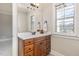Bathroom vanity with drawers and a marble countertop along with a window with plantation shutters at 164 Arabella Ct, Cary, NC 27518