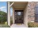 Inviting front entrance featuring a dark wood door with glass panels, surrounded by stone and brick accents at 164 Arabella Ct, Cary, NC 27518