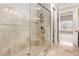 Walk-in shower featuring travertine tile, bench seating and glass surround at 164 Arabella Ct, Cary, NC 27518