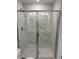 Luxurious tile shower enclosure with glass doors, featuring marble-look walls and a rainfall shower head at 1913 Fishamble St, Fuquay Varina, NC 27526