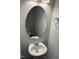 Bathroom featuring a modern round mirror, pedestal sink, chrome fixtures, and gray walls with white trim at 1913 Fishamble St, Fuquay Varina, NC 27526