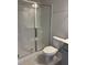 Modern bathroom featuring a glass-enclosed shower, toilet, and towel rack against gray walls at 1913 Fishamble St, Fuquay Varina, NC 27526