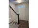 Inviting entryway with hardwood floors, a white front door and staircase with dark wood railing at 1913 Fishamble St, Fuquay Varina, NC 27526