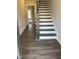 Inviting foyer with dark wood-look floors and staircase featuring stained banister and white risers at 1913 Fishamble St, Fuquay Varina, NC 27526