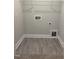 Empty laundry room with gray vinyl floors, new trim, and hookups at 1913 Fishamble St, Fuquay Varina, NC 27526