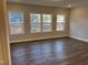 Spacious living room featuring hardwood floors and three large windows at 1913 Fishamble St, Fuquay Varina, NC 27526