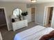 Bedroom showing neutral walls, carpet, a dresser with a round mirror, and open doorways leading to other rooms at 1913 Fishamble St, Fuquay Varina, NC 27526