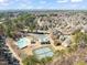 Aerial view of a community with a pool and tennis courts surrounded by green trees with the city in the distance at 1928 Jupiter Hills Ct, Raleigh, NC 27604