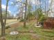 Expansive backyard with a path, lush trees, and view to a golf course at 1928 Jupiter Hills Ct, Raleigh, NC 27604
