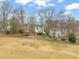 Spacious backyard view showing mature trees, lawn and neighboring homes in the distance at 1928 Jupiter Hills Ct, Raleigh, NC 27604