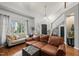 Light-filled living room with hardwood floors, large windows, and a staircase at 1928 Jupiter Hills Ct, Raleigh, NC 27604