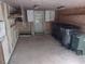 Open garage area features concrete flooring, a back door, and multiple trash bins for convenient waste disposal at 229 Short St, Wendell, NC 27591