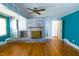 Open living room featuring hardwood floors, a cozy fireplace, and a ceiling fan for added comfort at 229 Short St, Wendell, NC 27591