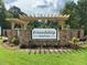 Friendship Station neighborhood entrance sign featuring a stacked stone base, pergola, and manicured lawn at 2323 Bay Minette Sta # 547, Apex, NC 27502