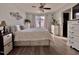 Bright bedroom with a ceiling fan, a bed with storage drawers, and views of the exterior through curtained windows at 2323 Turtle Point Dr, Raleigh, NC 27604