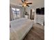 Bright bedroom with a ceiling fan, a bed with storage drawers, and views of the exterior through curtained windows at 2323 Turtle Point Dr, Raleigh, NC 27604
