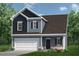 Charming two-story home with blue siding, a well-manicured lawn, and an attached two-car garage at 253 Deodora Ln, Cameron, NC 28326
