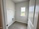 Well-lit laundry room with tile floors, storage shelves, and a window with a view at 253 Deodora Ln, Cameron, NC 28326