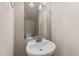 Powder room featuring a white pedestal sink, a well-lit mirror, and neutral wall paint at 264 Farrington Dr, Clayton, NC 27520