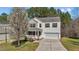 Charming two-story home with a well-maintained lawn, a blooming tree, and an inviting front porch at 264 Farrington Dr, Clayton, NC 27520
