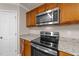 Close up of kitchen with wood cabinets, granite counters and stainless steel oven at 264 Farrington Dr, Clayton, NC 27520