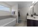 Bathroom featuring a soaking tub, large window, double sink vanity and glass enclosed shower at 277 Martins Mill Ct, Wendell, NC 27591