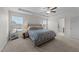 Bright bedroom with a ceiling fan, large windows, and patterned bedding in a neutral color palette at 277 Martins Mill Ct, Wendell, NC 27591