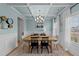 Elegant dining room features paneled walls, a modern chandelier, and natural light streaming through the windows at 277 Martins Mill Ct, Wendell, NC 27591