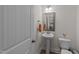 A cozy powder room showcasing a modern pedestal sink, and a well-lit mirror at 277 Martins Mill Ct, Wendell, NC 27591