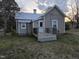 Back exterior of tan home with a small wooden deck and a white lattice surround at 301 Wilson St, Franklinton, NC 27525
