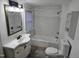 Bright white bathroom with a new toilet, sink, vanity, new flooring, and bathtub at 301 Wilson St, Franklinton, NC 27525