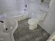 Bathroom featuring a white toilet, sink, vanity, and shower-tub combo with tile surround and new flooring at 301 Wilson St, Franklinton, NC 27525