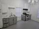 Bright kitchen featuring grey cabinets, stainless steel appliances, and a white backsplash and countertops at 301 Wilson St, Franklinton, NC 27525