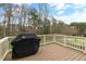 An expansive wooden deck with white railings provides space for outdoor grilling and a serene backyard view at 306 Village Orchard Rd, Cary, NC 27519