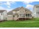 Back exterior view of a two-story house with a deck and a covered screened-in porch overlooking a green lawn at 306 Village Orchard Rd, Cary, NC 27519