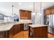 Modern kitchen with an island, stainless steel appliances, custom wood cabinets, and granite countertops at 306 Village Orchard Rd, Cary, NC 27519
