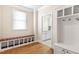 Mudroom with built-in bench, storage cubbies and coat hooks; doorway leads into laundry room at 306 Village Orchard Rd, Cary, NC 27519