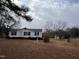 Cozy home featuring manicured landscaping, a charming birdhouse, and a spacious yard at 3211 Kipling Rd, Fuquay Varina, NC 27526
