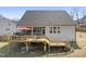 Home exterior overlooking a large backyard with a wooden deck featuring an outdoor kitchen with grilling space at 33 Song Breeze Cir, Angier, NC 27501