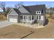 Charming home features stone accents, attached garage, front porch, freshly landscaped yard, and privacy fence at 33 Song Breeze Cir, Angier, NC 27501