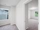 Hallway with a window, neutral walls, carpeted flooring, and a view to a bright bedroom at 3730 Mason Bluff Dr, Raleigh, NC 27616