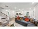 Open-concept living room features a large gray sofa, dining area, and modern kitchen with white cabinetry and stainless appliances at 3730 Mason Bluff Dr, Raleigh, NC 27616
