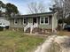 A single-story home with vinyl siding and a front yard with mature trees and small staircase to enter at 402 Todd Hill Dr, Wendell, NC 27591