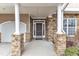 Inviting home entrance featuring stone accents, white pillars and a dark front door at 413 Westfalen Dr, Cary, NC 27519