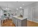Open-concept kitchen with island seating and views to the living room and staircase at 413 Westfalen Dr, Cary, NC 27519