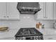 Close-up of a stainless steel gas range with sleek vent hood and white backsplash at 413 Westfalen Dr, Cary, NC 27519