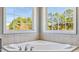 Bathroom with tiled corner tub and natural light from large windows at 424 Crystal Spring Dr, Sanford, NC 27332