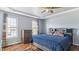 Bedroom featuring a tray ceiling, two windows, hardwood floors, dresser and headboard with storage at 424 Crystal Spring Dr, Sanford, NC 27332
