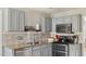 This kitchen is equipped with stainless steel appliances, gray cabinets, and a tiled backsplash at 424 Crystal Spring Dr, Sanford, NC 27332
